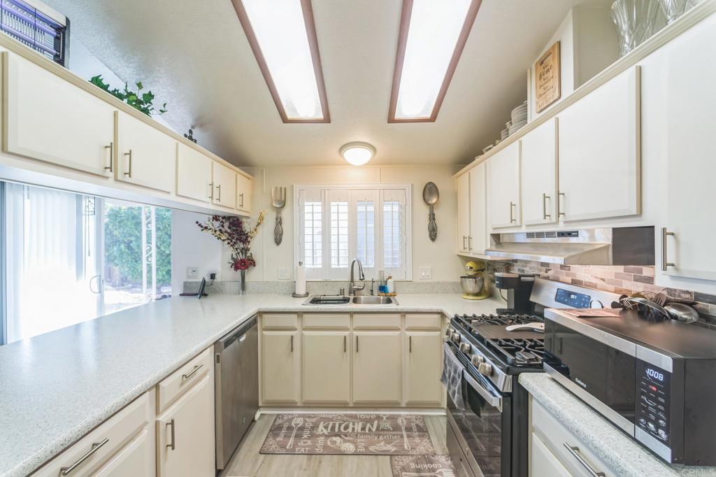 27250 Murrieta Road, Unit 364 Menifee, CA 92586 - Photo 2 of 17 a kitchen with a sink stove cabinets and wooden floor