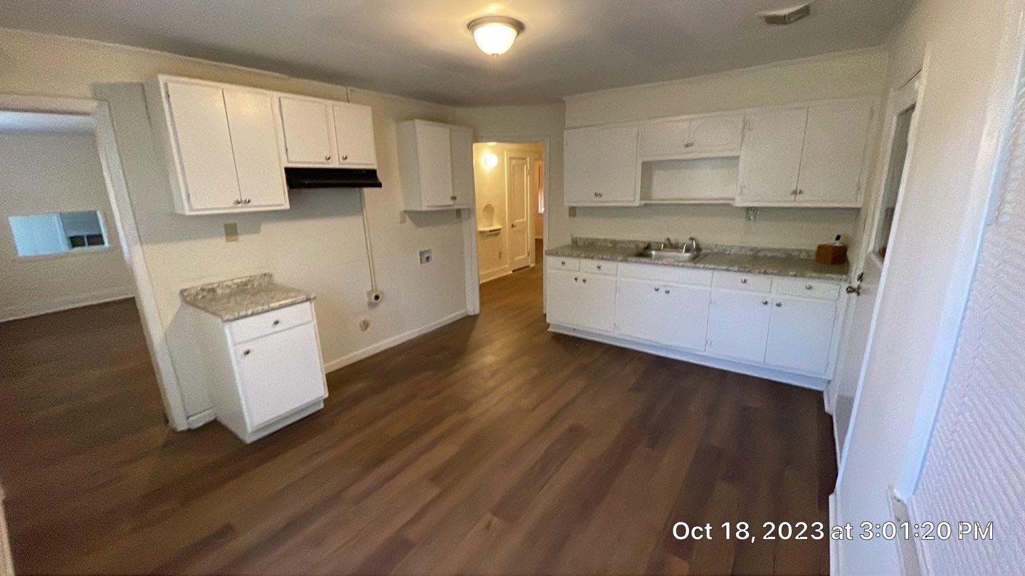 75 East Peebles Road Memphis, TN 38109 - Photo 10 of 10 a kitchen with granite countertop white cabinets and wooden floor