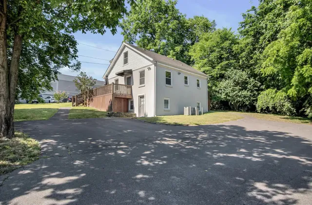 a view of a house with a yard and basketball ground