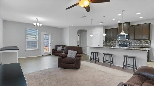 a living room with furniture a flat screen tv and kitchen view