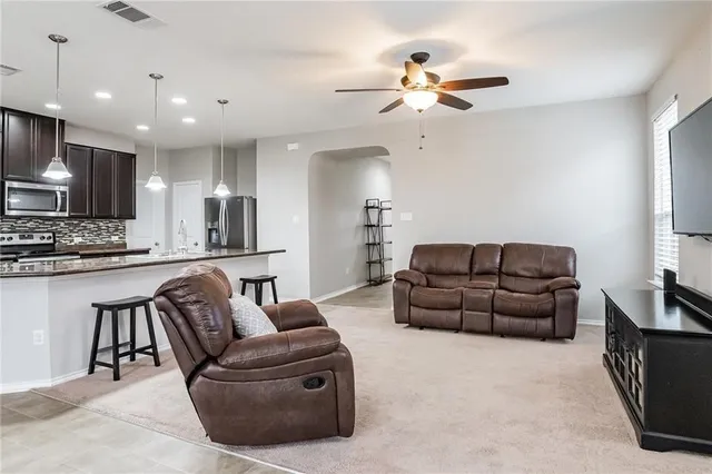 a living room with furniture kitchen and a chandelier