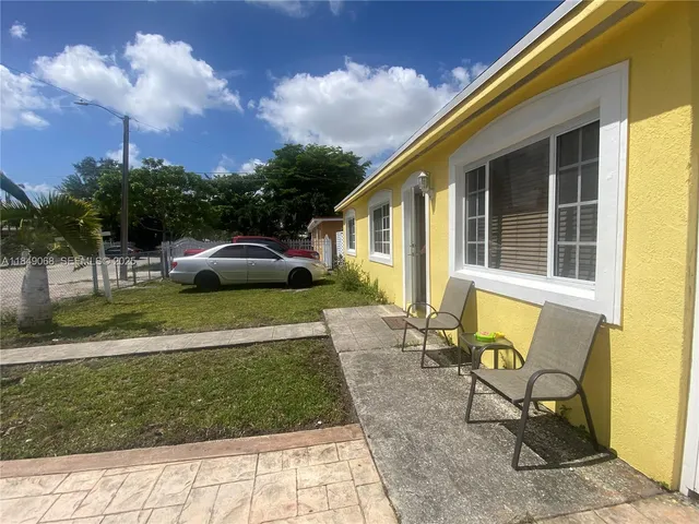 a view of house with backyard and outdoor seating