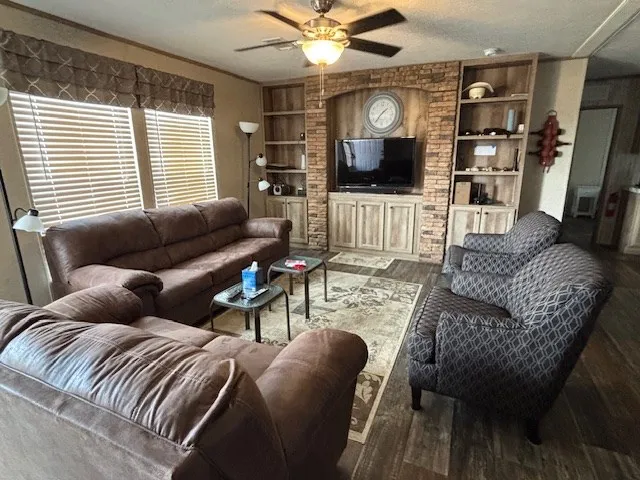 a living room with furniture a flat screen tv and a large window