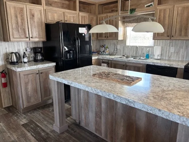 a kitchen with stainless steel appliances granite countertop wooden cabinets a sink a stove and a refrigerator