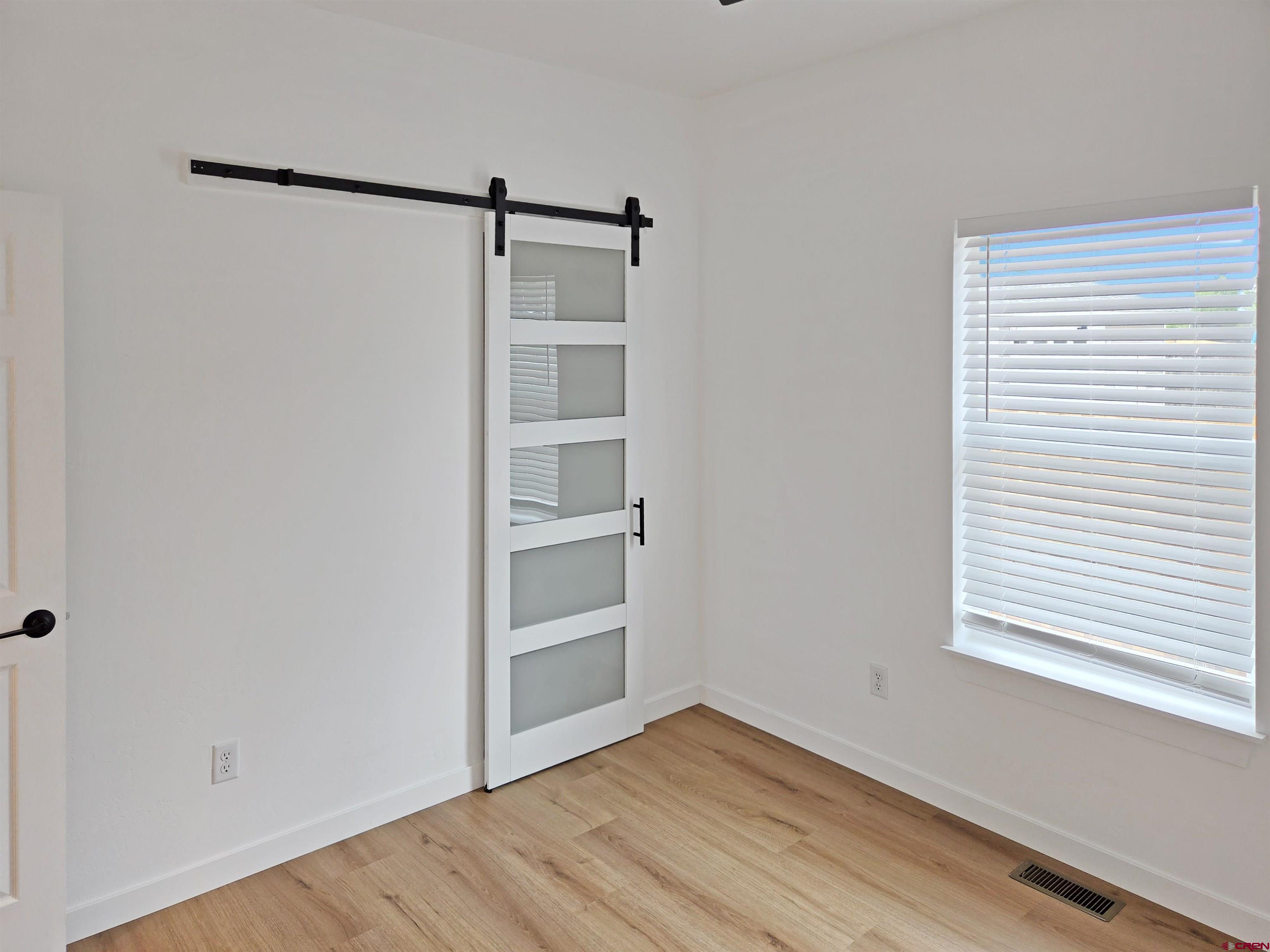 1456 Acoma Street Cortez, CO 81321 - Photo 15 of 26 a view of an empty room with wooden floor and a window