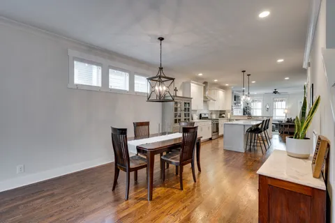 a dining room with furniture a chandelier and wooden floor