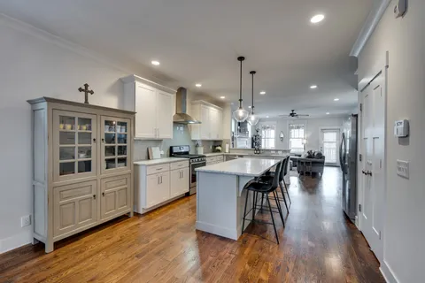 a kitchen with counter top space a sink appliances and wooden floor