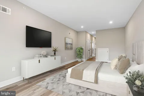 a spacious bedroom with a bed and a flat screen tv