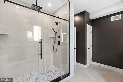 a bathroom with a shower and a glass door