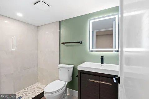 a bathroom with a sink a toilet and shower