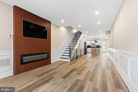a view of a hallway with wooden floor and staircase