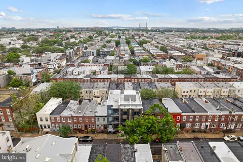 an aerial view of a city with lots of residential buildings ocean and mountain view in back