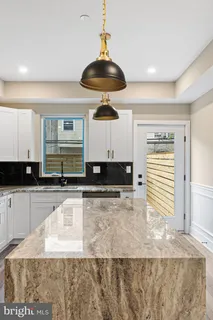 a kitchen with stainless steel appliances granite countertop a sink a stove and a wooden cabinets
