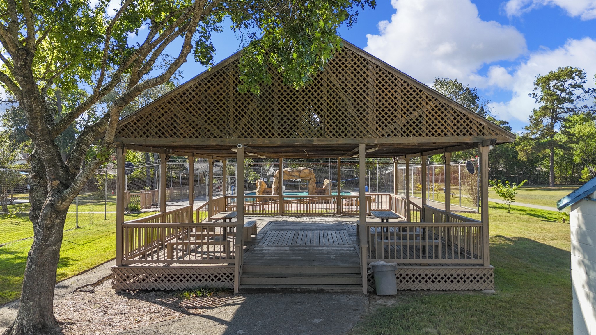 23826 Lestergate Drive Spring, TX 77373 - Photo 42 of 45 Set beneath the trees, this covered community pavilion offers a shaded place to gather, picnic, or simply take a break outdoors, with the pool area visible just beyond. It’s another easy extension of the Birnam Wood lifestyle and a convenient spot to enjoy time outside close to home.