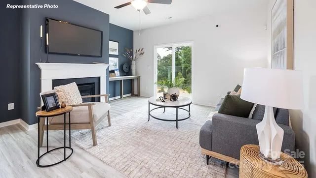 a living room with furniture a flat screen tv and a fireplace