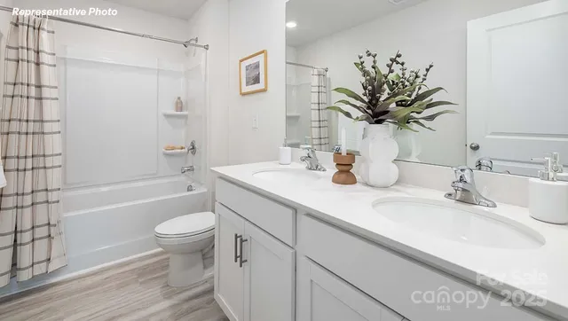 a bathroom with a granite countertop sink toilet a large mirror a bathtub and shower