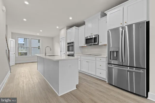 a kitchen with white cabinets and stainless steel appliances