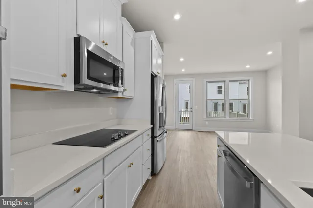 a kitchen with kitchen island white cabinets appliances and sink