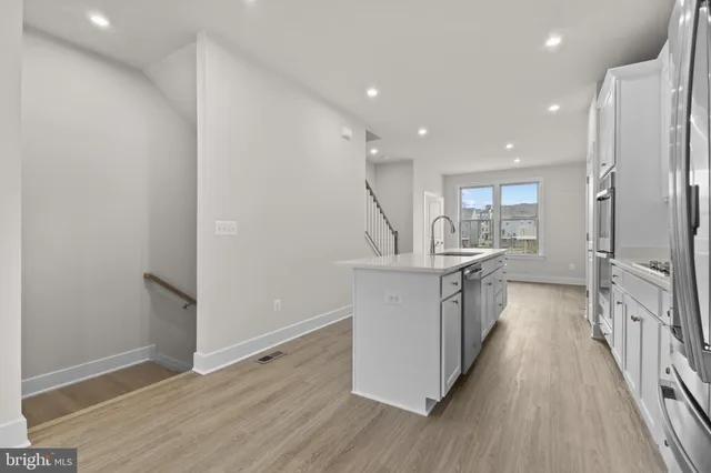 a kitchen with a sink and wooden floor