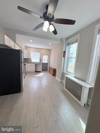 a view of a livingroom with furniture a ceiling fan and wooden floor