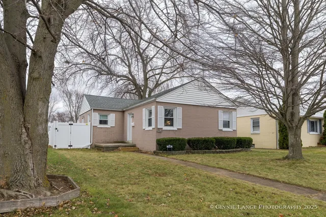 a view of a house with a yard covered with trees