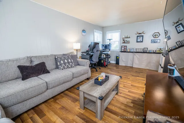 a living room with furniture and a wooden floor
