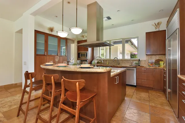 a kitchen with stainless steel appliances granite countertop a stove a sink and a refrigerator