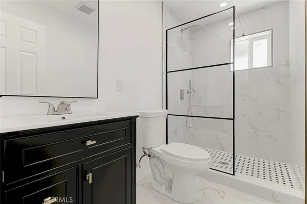 a bathroom with a sink vanity and toilet