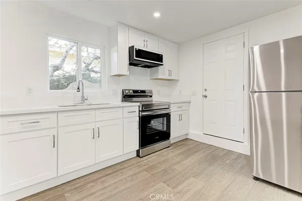 a kitchen with a refrigerator stove and white cabinets