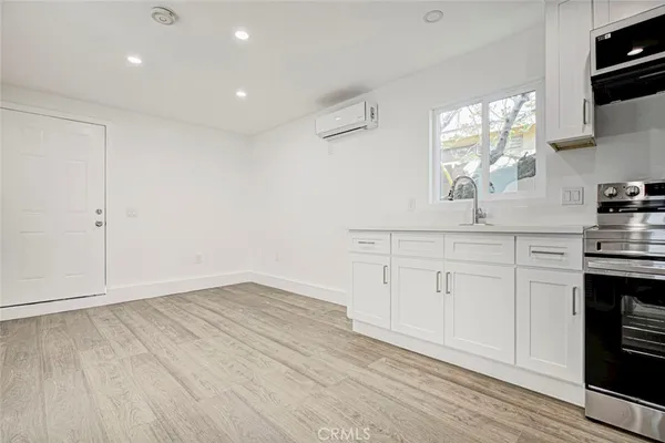 a kitchen with granite countertop white cabinets and white appliances