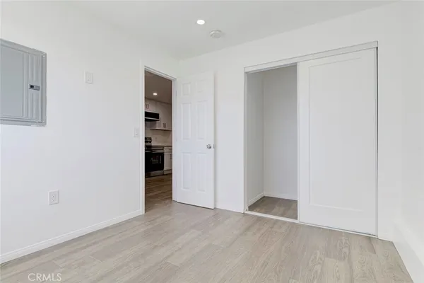 an empty room with wooden floor and closet