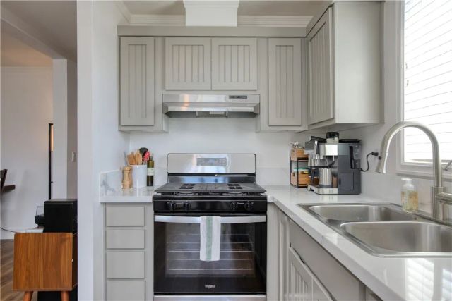 a kitchen with stainless steel appliances granite countertop a sink stove and cabinets