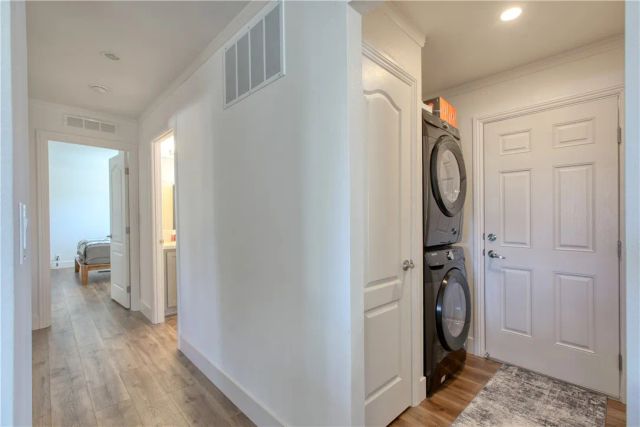 a view of a hallway with wooden floor and a bathroom
