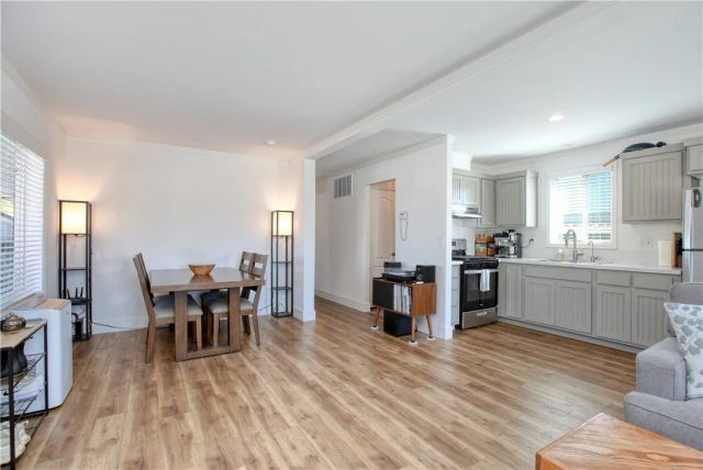 a kitchen with stainless steel appliances kitchen island granite countertop a dining table chairs and granite counter tops