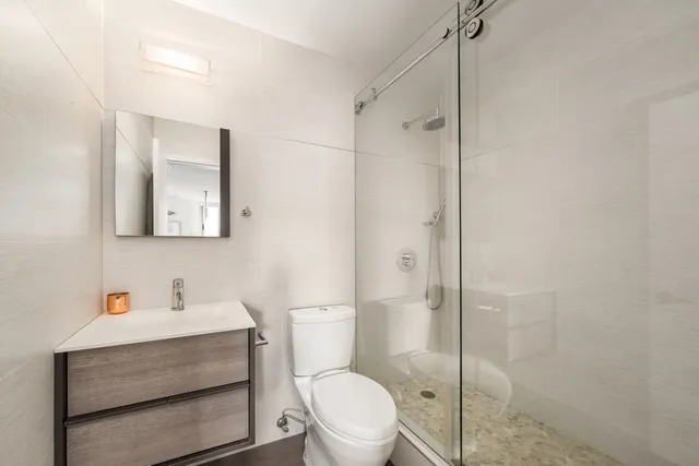 a bathroom with a sink a toilet and shower