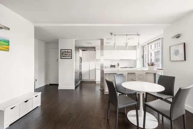 a kitchen with a dining table chairs and white appliances