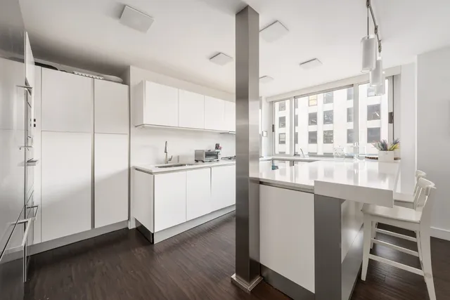 a kitchen with a refrigerator and white cabinets