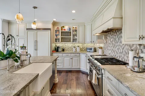 a kitchen with stainless steel appliances kitchen island granite countertop a sink and cabinets