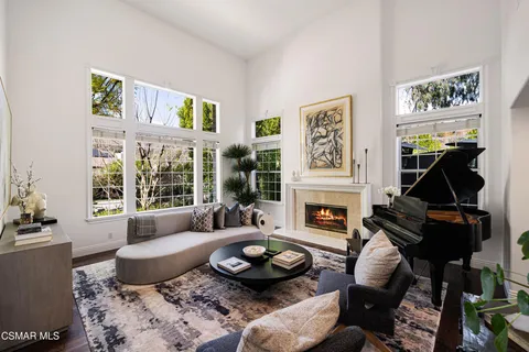 a living room with furniture a fireplace and a large window