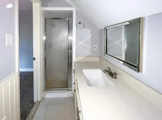 a bathroom with a tub sink and mirror