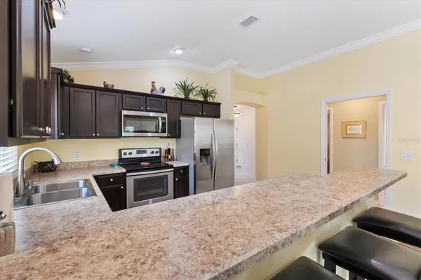 a kitchen with granite countertop a stove refrigerator and microwave