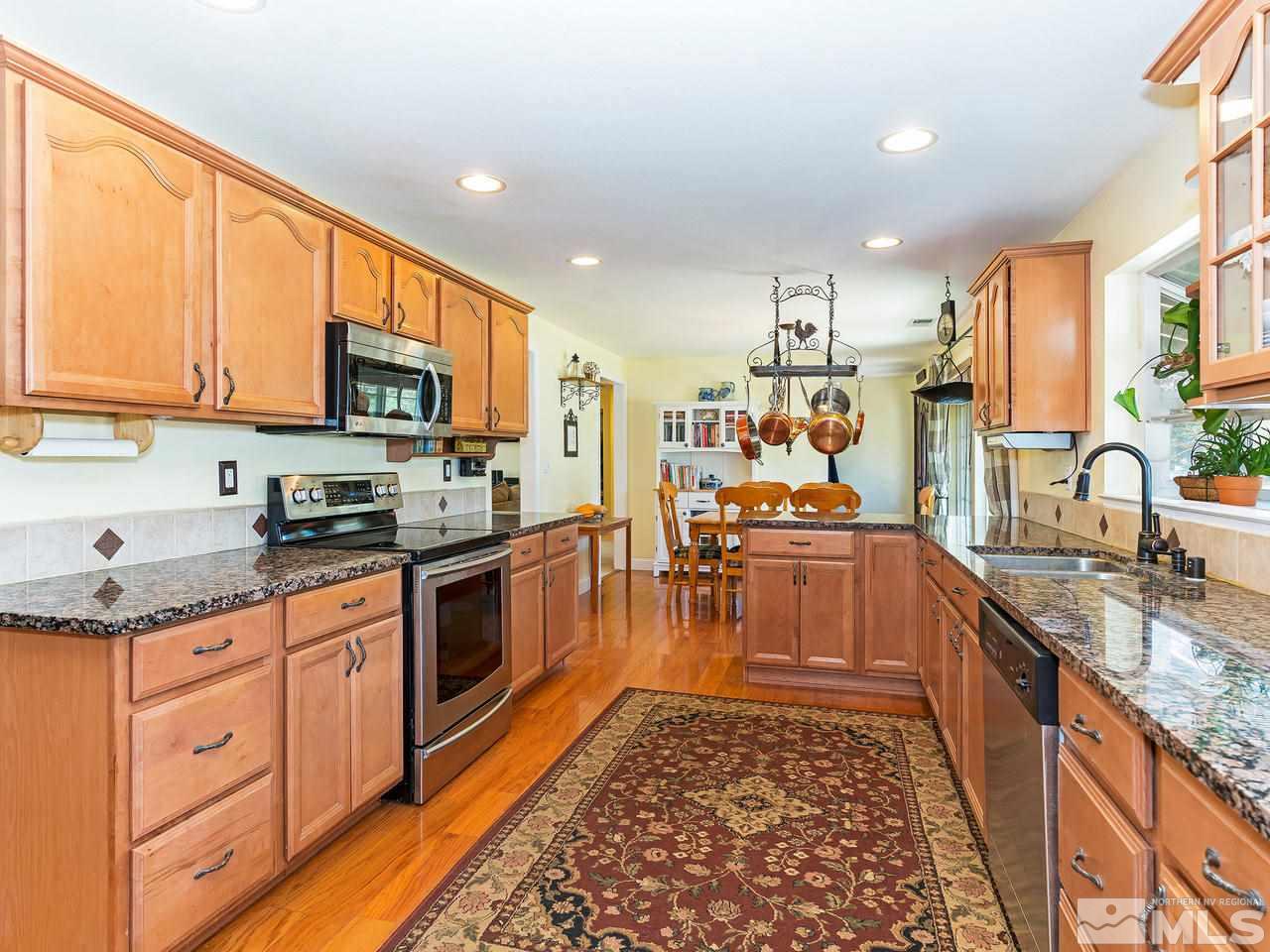 14465 Shadow Hills Drive Reno, NV 89521 - Photo 6 of 15 a large kitchen with stainless steel appliances granite countertop a stove a sink dishwasher and a microwave oven with cabinets