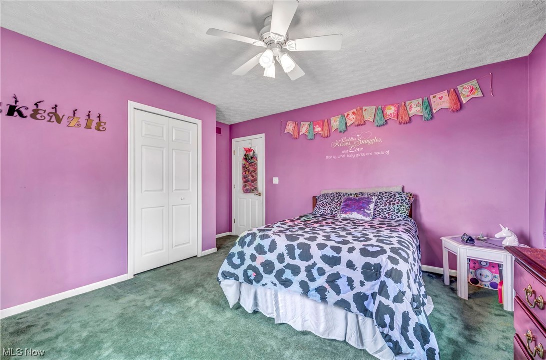 3324 Poe Road Medina, OH 44256 - Photo 16 of 26 Bedroom with dark carpet, a closet, ceiling fan, and a textured ceiling