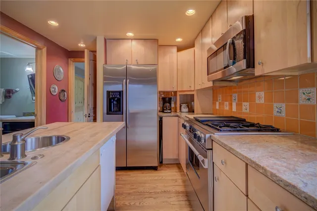 a kitchen with stainless steel appliances granite countertop a sink and a stove