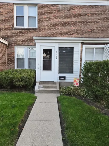 a front view of a house with a garden and plants