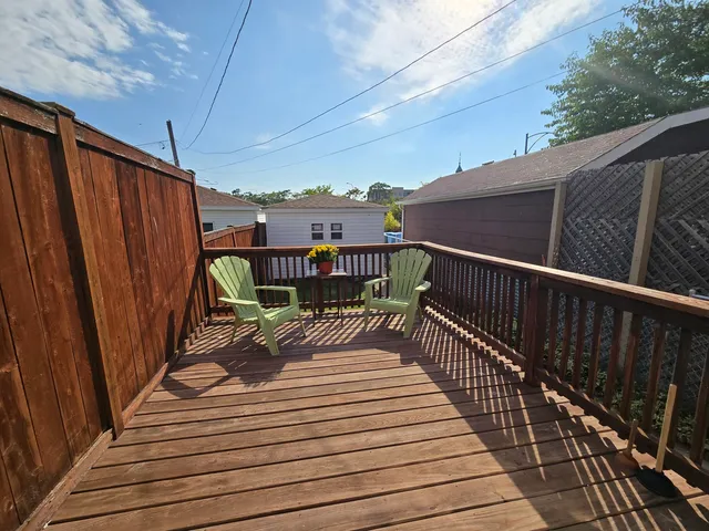 a view of a balcony with two chairs and wooden floor