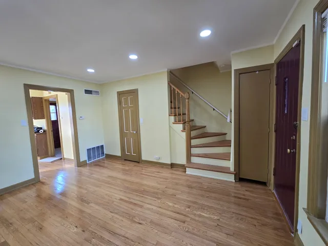 a view of a hallway with wooden floor and entryway