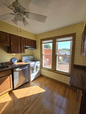a kitchen with stainless steel appliances granite countertop a stove a sink and a microwave