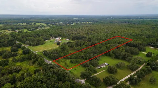 an aerial view of residential houses with outdoor space and river