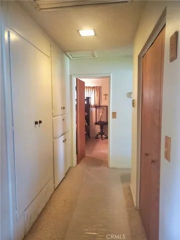 a view of a hallway with a livingroom and a bathroom